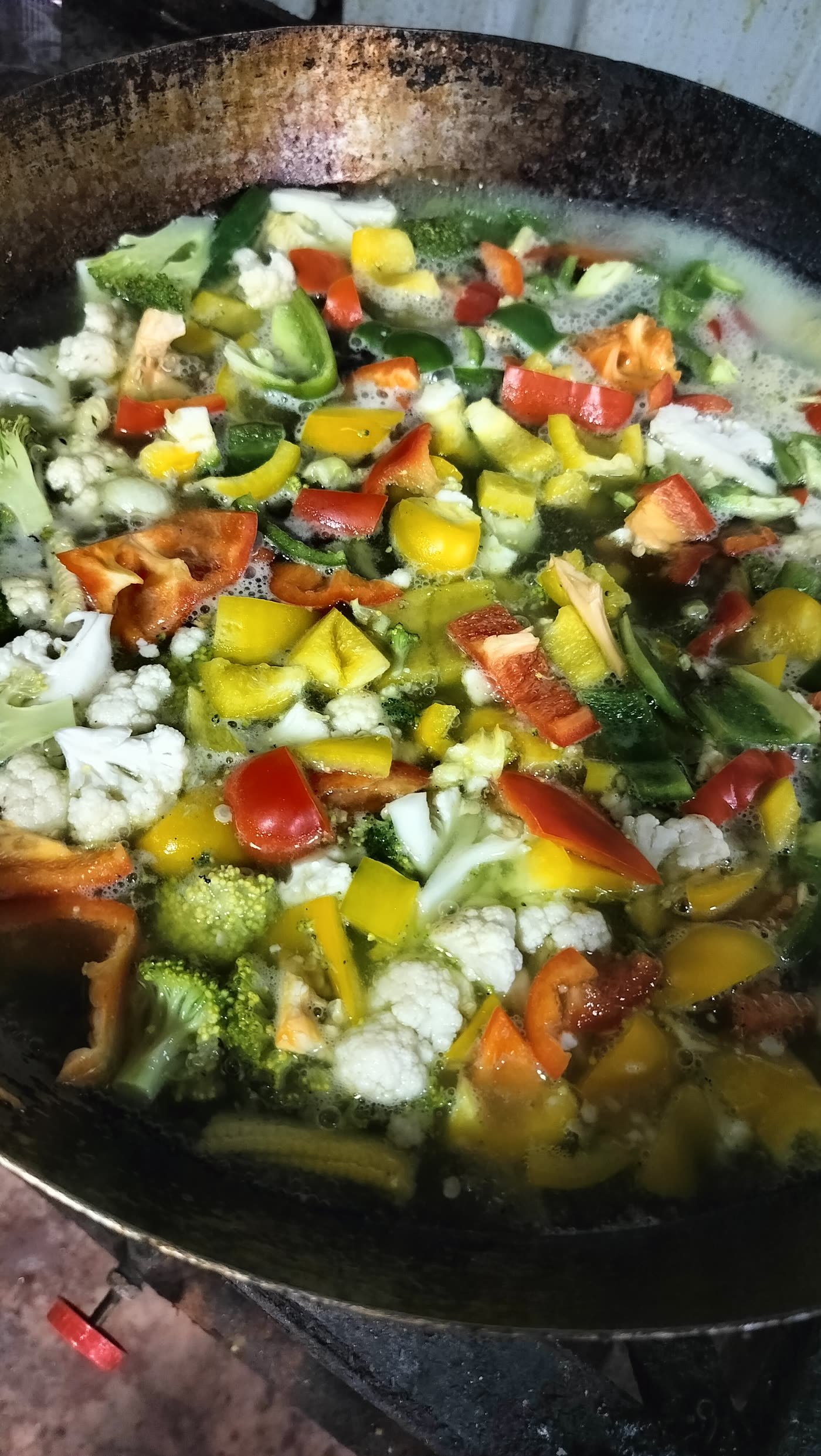 Mixed vegetables cooking in a large wok
