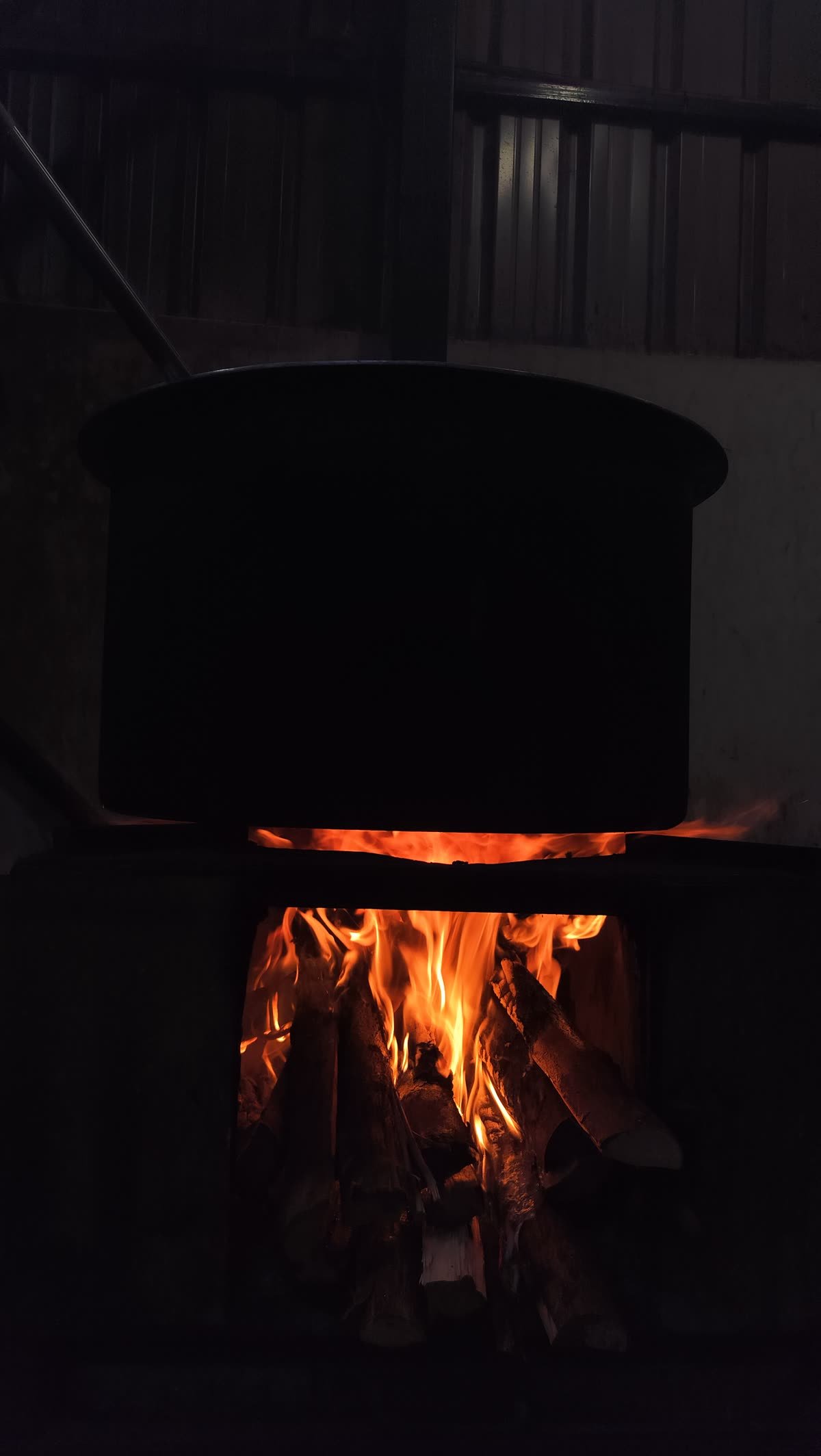 An open fire burning under a large cooking vessel